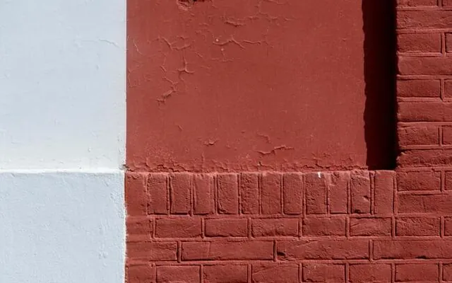 Brick-red coating over a textured masonry wall