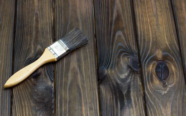 Paintbrush resting on stained wood boards