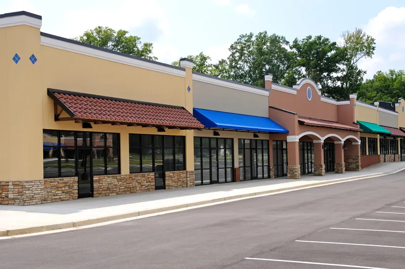Row of painted retail storefronts with colored awnings